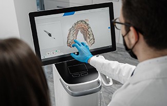 dentist looking at digital scan of patient’s teeth 