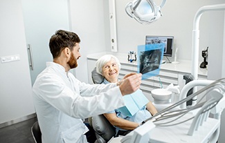 older patient smiling while talking to dentist