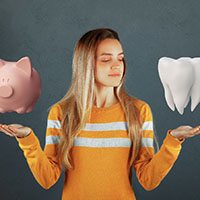 woman with tooth and piggy bank cosmetic dentistry Reno  