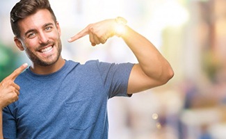 young man pointing to his smile with straight white teeth 