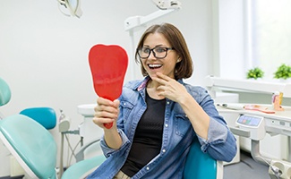 young woman admiring her new dental implants in Reno