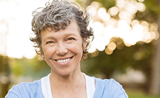 woman smiling while standing outside 