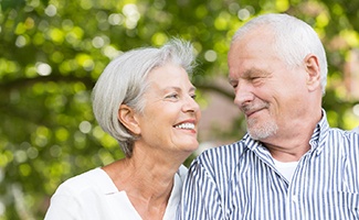 older couple smiling while looking at each other 