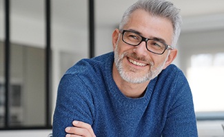 man smiling with arms crossed