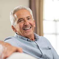 Older man with dentures smiling