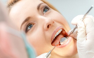 A dentist checking a patient’s teeth