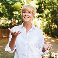 Woman throwing an apple into the air