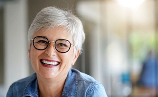 Senior woman with glasses and implant dentures in Reno, NV