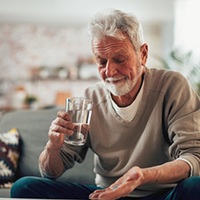 a mature man taking medications for dental implant aftercare