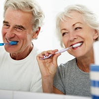 a mature couple brushing their teeth together