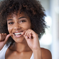 Reno patient gently flossing teeth after gum disease treatment