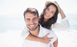 couple smiling on the beach after teeth whitening in Reno