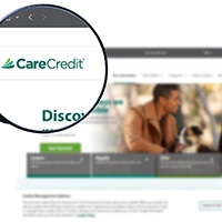 a magnifying glass zooming in on a CareCredit logo
