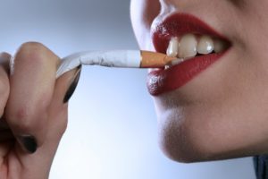 woman biting cigarette red lipstick