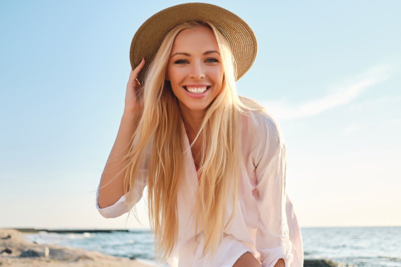 woman smiling outside at the beach during summer vacation