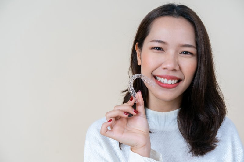 Young woman holding Invisalign tray