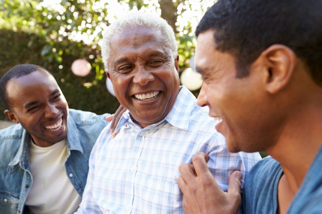 Three men of different ages talking and laughing outside