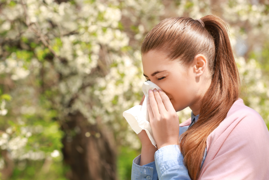 Woman sneezing outside in a park