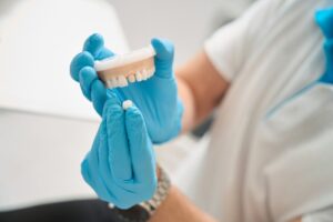 Hygienist holding mouth mold and dental crown.