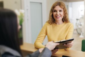 Woman filling out paperwork to receive a dental crown